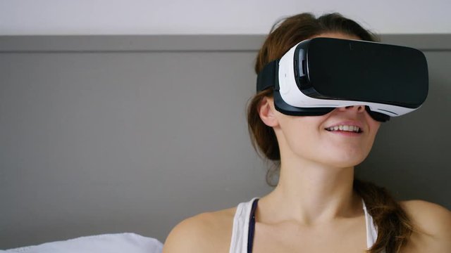4K Young woman in her bedroom using a virtual reality headset, with space for text