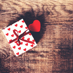 Valentines Day background with red heart and present gift on woo