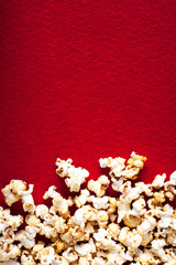 Popcorn popcorn on red textured background close up macro.