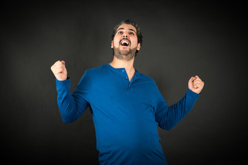 Naklejka premium Handsome man doing different expressions in different sets of clothes: arms raised