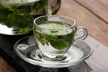 Tea. Mint Tea. Herbal tea. Mint leaf. Mint leaves. Tea in a glass cup, mint leaves, dried tea, sliced lime. herbs tea and mint leaves on a slate plate in a restaurant or teahouse tea room.