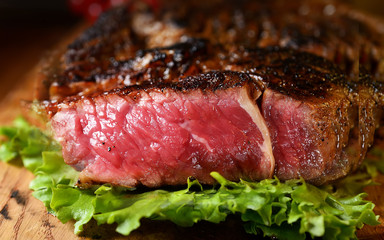 Steak with herbs and beer on a wooden background