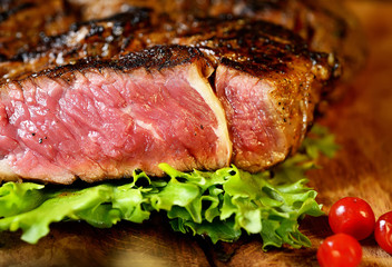 Steak with herbs and beer on a wooden background