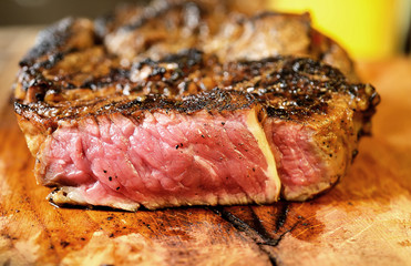 Steak with herbs and beer on a wooden background