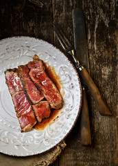 Sliced medium rare grilled Beef steak Ribeye on a plate