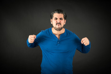 Naklejka premium Handsome man doing different expressions in different sets of clothes: angry