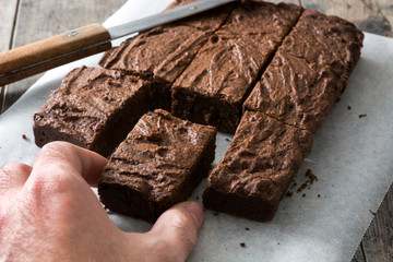Hand catching a chocolate brownie portion
