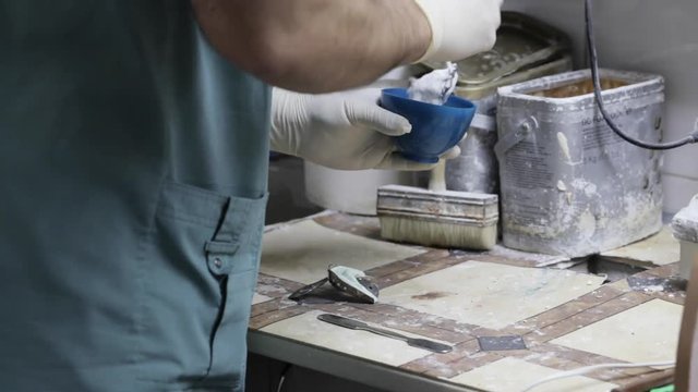 Close-up of ceramet implant creature process at laboratory. Technician creating a model of jaw with gipsum for create ceramet implant.