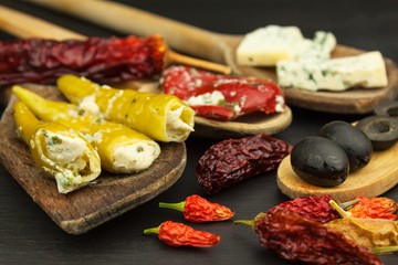 Detailed view of stuffed chillies. Preparing for the summer grill party. Dried chillies and spicy peppers filled with cheese. Delicacy suitable for grilled meats. Chillies and cheese.
