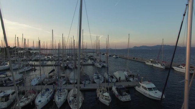 Yacht marina in Kos island. The camera moves between the masts of sailing yachts moored in the marina.  Aerial view.