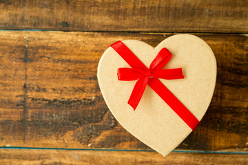 Beautiful gift with heart shape and red ribbon