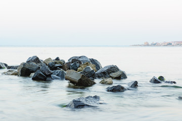 the stones on the beach under the incoming wave
