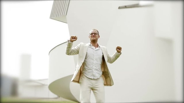 successful young businessman in white casual suit jumping in slow motion.