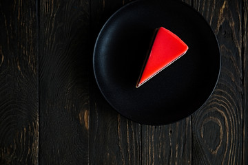 Piece of strawberry jelly cake.  Dark wooden background. Minimal concept. Top view. Copy space for...