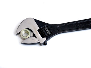 adjustable wrench and nut on white background