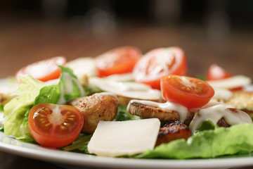 caesar salad with cherry tomatoes on wooden table