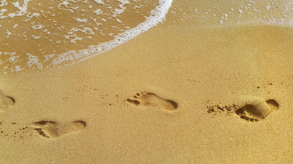 Sea water and footprints in the sand at the beach