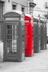 Fototapeta premium Five Red London Telephone boxes in portrait in black and white with one red