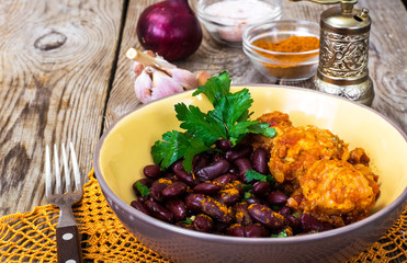 Meatballs in vegetable sauce with side dish of red beans
