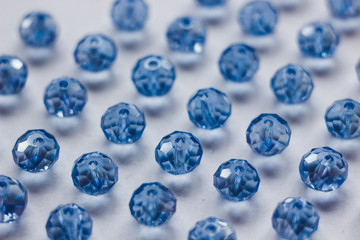 blue glass beads polyhedron shape pattern closeup on a white background
