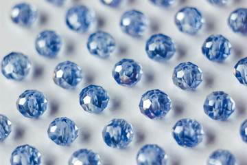 blue glass beads polyhedron shape pattern closeup on a white background