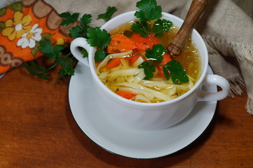 Hot traditional chicken soup in a white dish - energy and warming meal on a cold day
