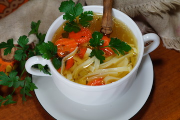Hot traditional chicken soup in a white dish - energy and warming meal on a cold day

