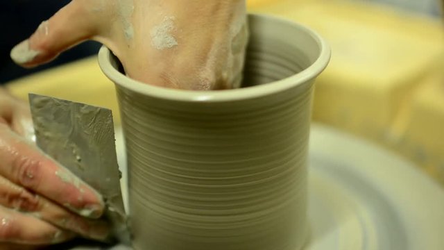 A woman models a pot on a potter's wheel - timelapse - closeup