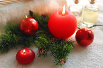 Fototapeta na wymiar Big red candle and Christmas decorations, closeup