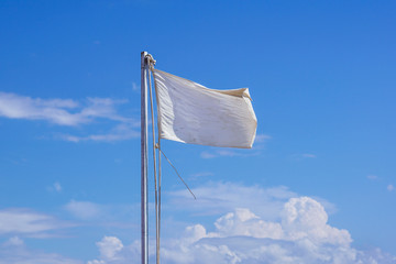 Empty white clear flag waving against clean blue sky, close up,