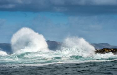 Sea landscape.  Clouds sky, waves with splashes, mountains silhouettes. False bay. South Africa.