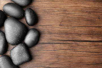Spa stones on wooden background, top view