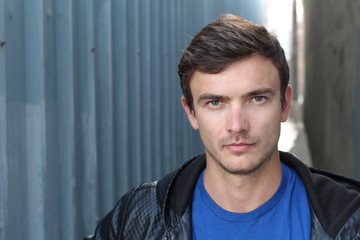 Obraz premium Portrait of young man outdoors with very handsome face in casual clothes against alley way urban background