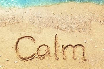Word CALM on beach sand