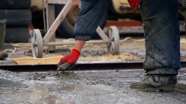 Pouring, Laying Concrete at the Construction Site using Buckets of Cement. Slow Motion