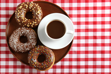Cup of coffee with donuts on table