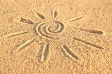 Sun drawn on sea sand, close up view