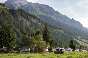 Cars and campervans in an outdoor mountain camping site staying here overnight