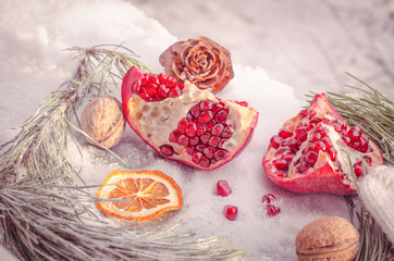 Winter scene with pomegranate, cones, branch of pine and orange 