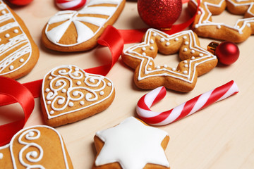 Tasty gingerbread cookies and Christmas decor on wooden background