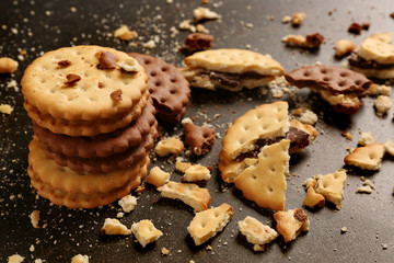 Tasty cookies with crumbs on dark background