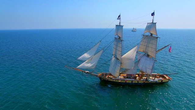 Tall ships at sea, majestic vessels sailing in open waters in good weather.

