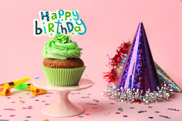 Happy birthday cupcake on stand on pink background