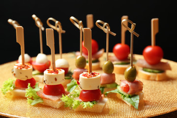 Set of delicious canapes on metal tray closeup