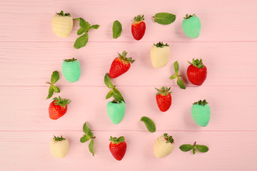 Delicious strawberries with chocolate and mint on pink wooden background