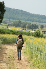 Fototapeta na wymiar Girl wearing a backpack walking down on road alone.