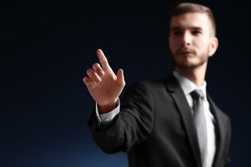 Businessman hand pointing, dark background