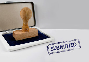 Wooden stamp with ink on desk SUBMITTED