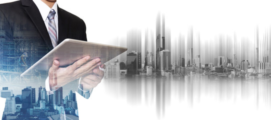 Businessman working on digital tablet with double exposure developing city