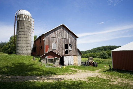 Agricultural background. A farm at Midwest USA. Wisconsin rural landscape with old farm buildings and utensils.